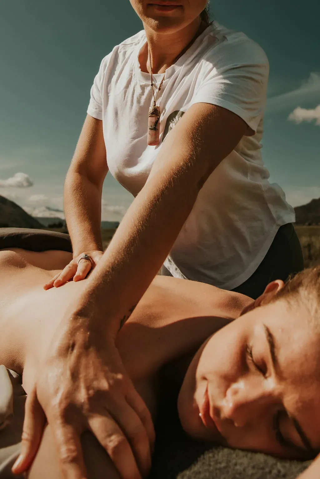 Smiling massage therapist using deep tissue technique with a client